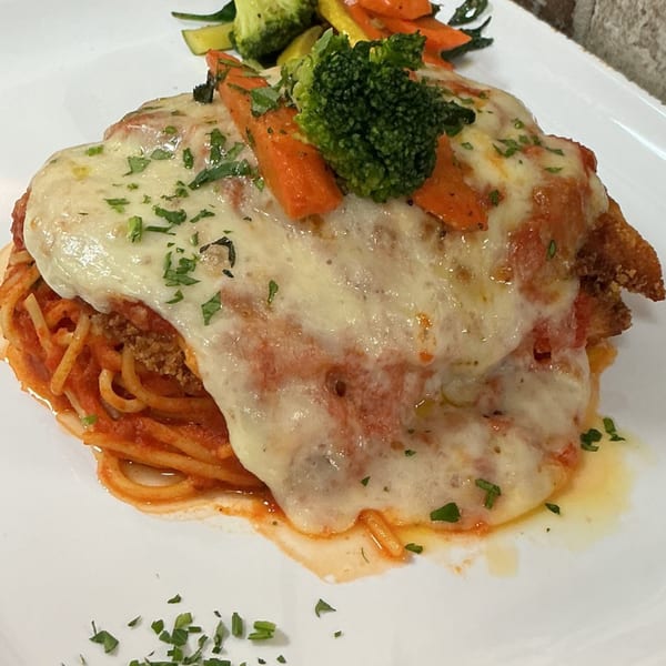 Chicken parmesan with melted cheese, tomato sauce, spaghetti, and a side of broccoli and carrots.